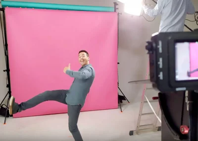 Hervé éclairant un fond coloré pour une publicité cinéma